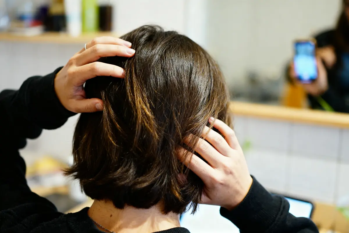 Femme analysant la croissance de ses cheveux pour savoir en combien de temps ils poussent