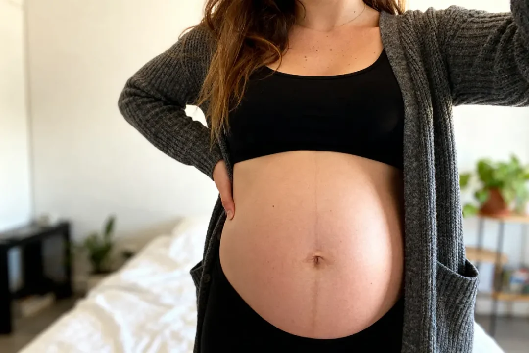 Femme enceinte, ventre gonflé sous la poitrine chez la femme, main sur la hanche